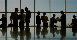 Shadowed group of business people in front of window